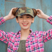 Load image into Gallery viewer, Girl wearing hand-tailored camouflage women’s baseball cap with scrunchies for space buns and pigtails hairstyles 