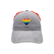Load image into Gallery viewer,  Hand-tailored Rainbow Heart on charcoal women’s baseball cap with red scrunchies for space buns and pigtails hairstyles 